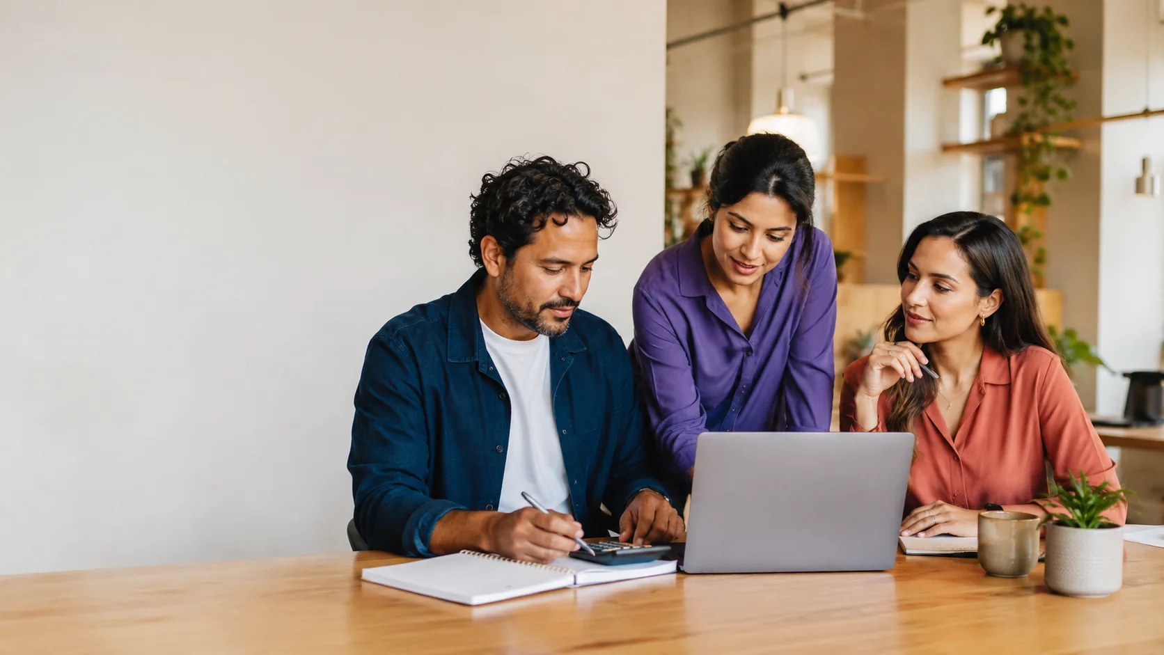 A small business team reviewing numbers and a project together on a laptop